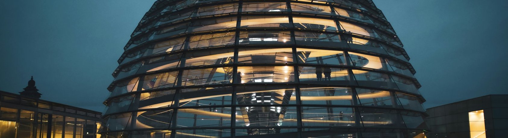 Beleuchtete Glaskuppel des Reichstagsgebäudes in Berlin bei Dämmerung