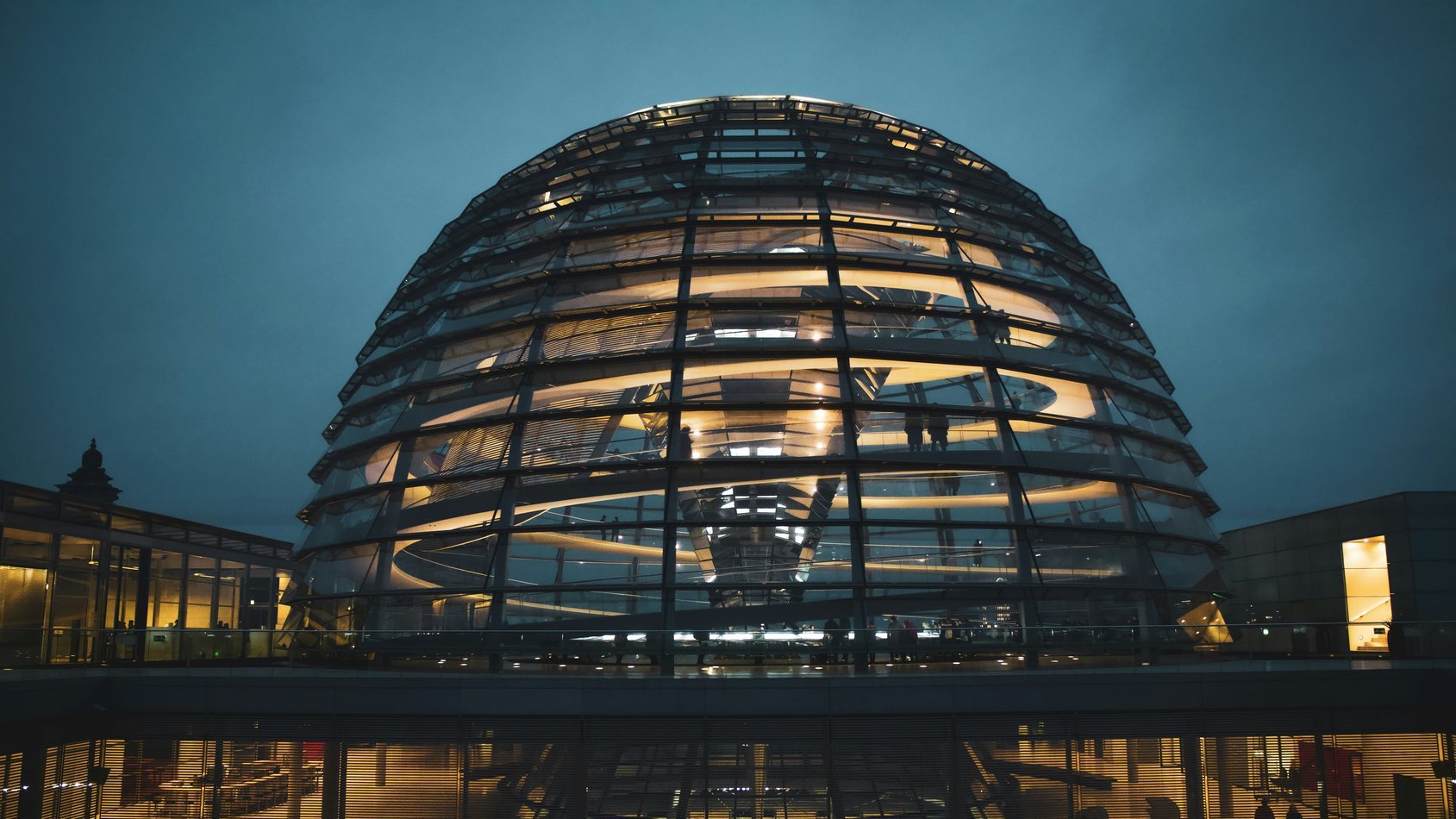 Beleuchtete Glaskuppel des Reichstagsgebäudes in Berlin bei Dämmerung