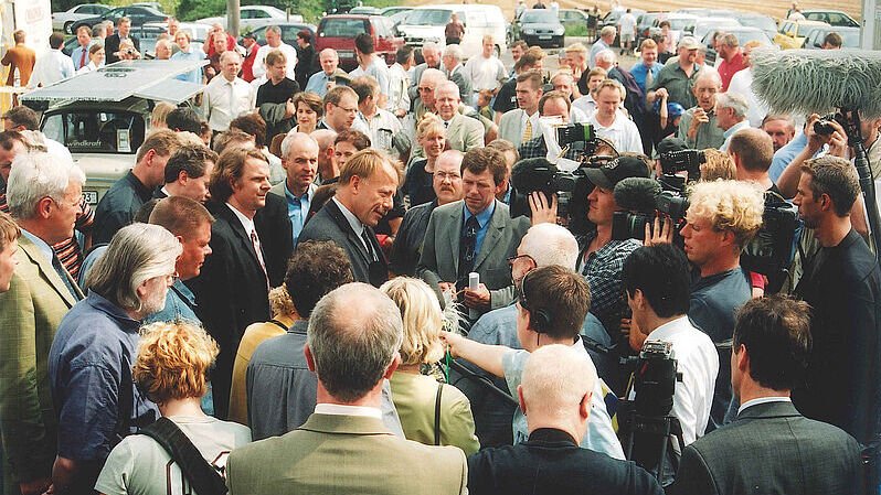Viele Menschen hören ein Interview zu, wobei dies von Kameras aufgenommen wird