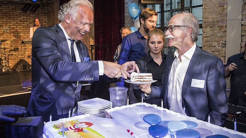 Hermann Albers reicht Kuchen an einen älteren Herren
